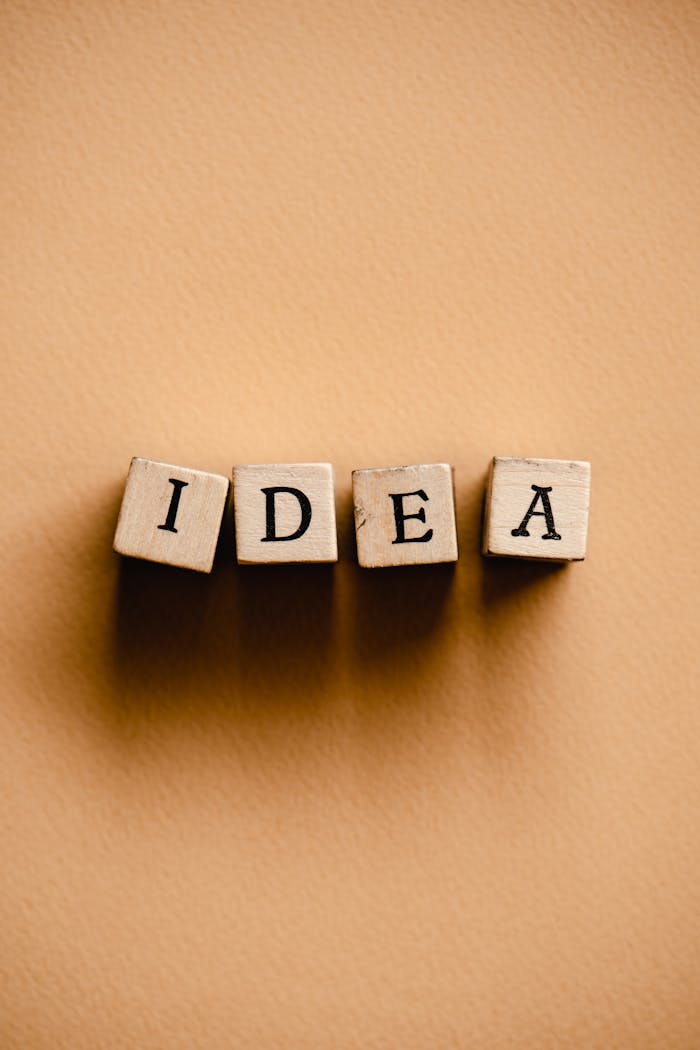 Wooden letter tiles spelling 'Idea' on a beige surface. Perfect for creativity and inspiration themes.